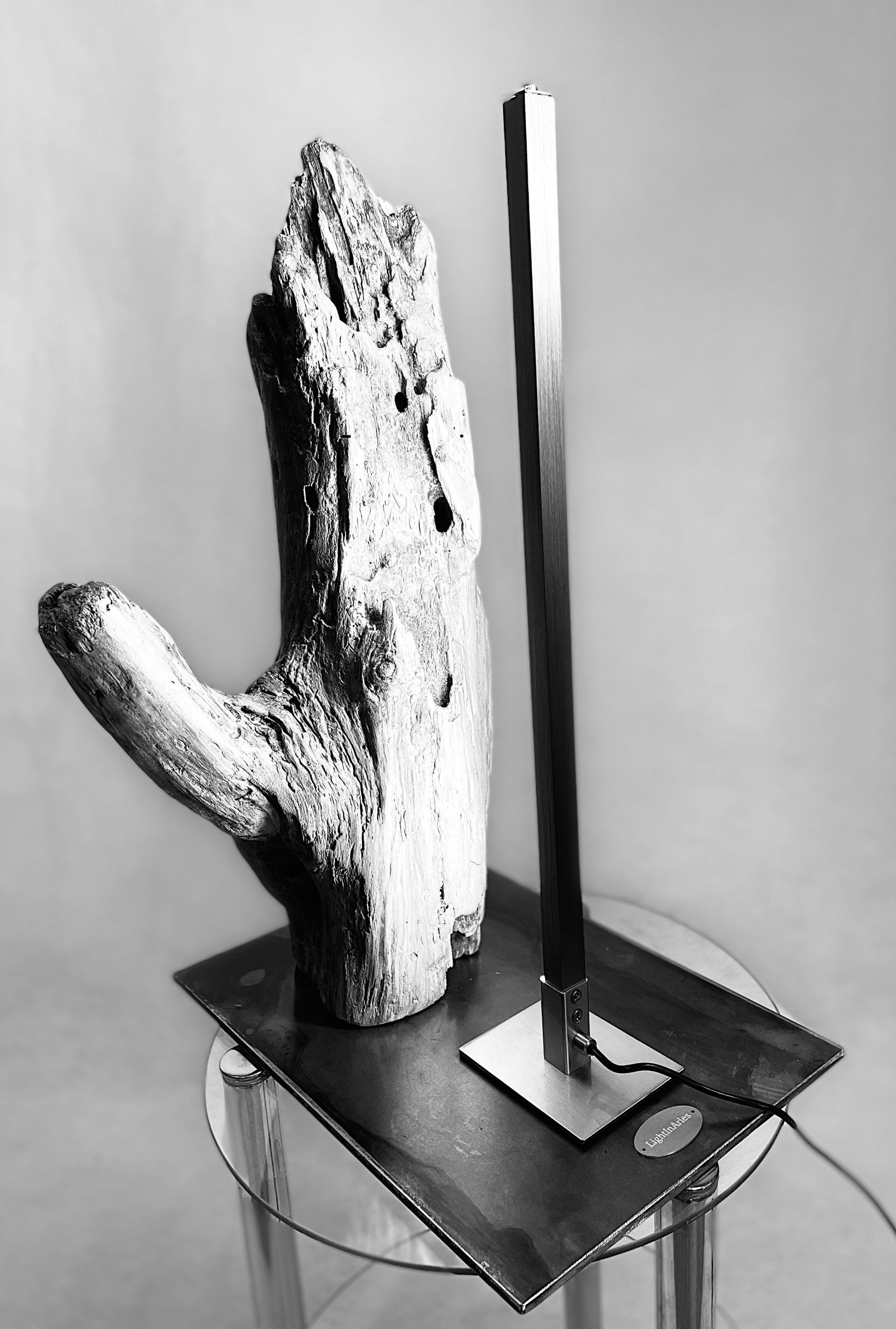 Une main taillée en bois avec une lampe à côté.