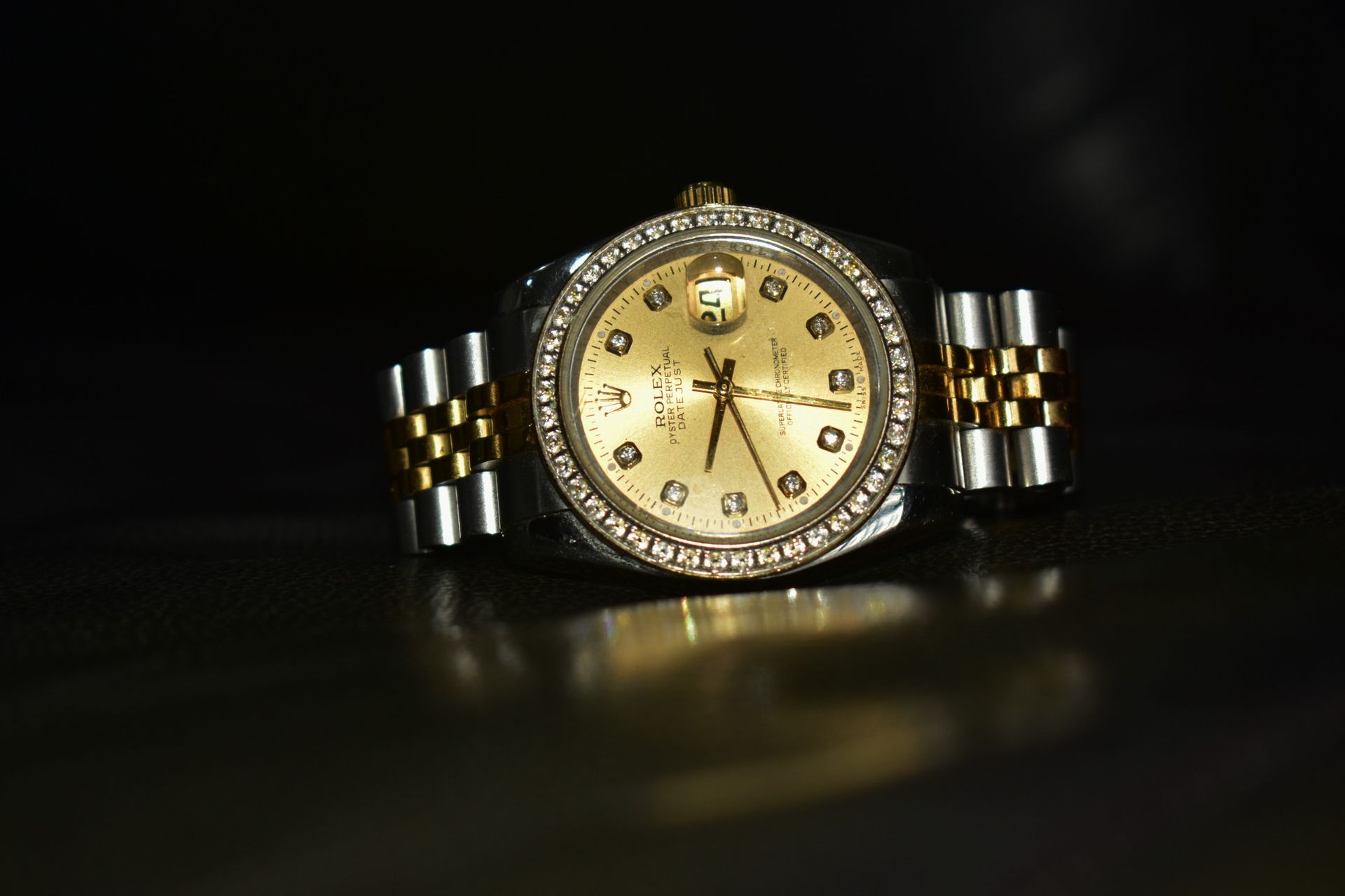 Un primer plano de un reloj Rolex sobre una superficie negra.