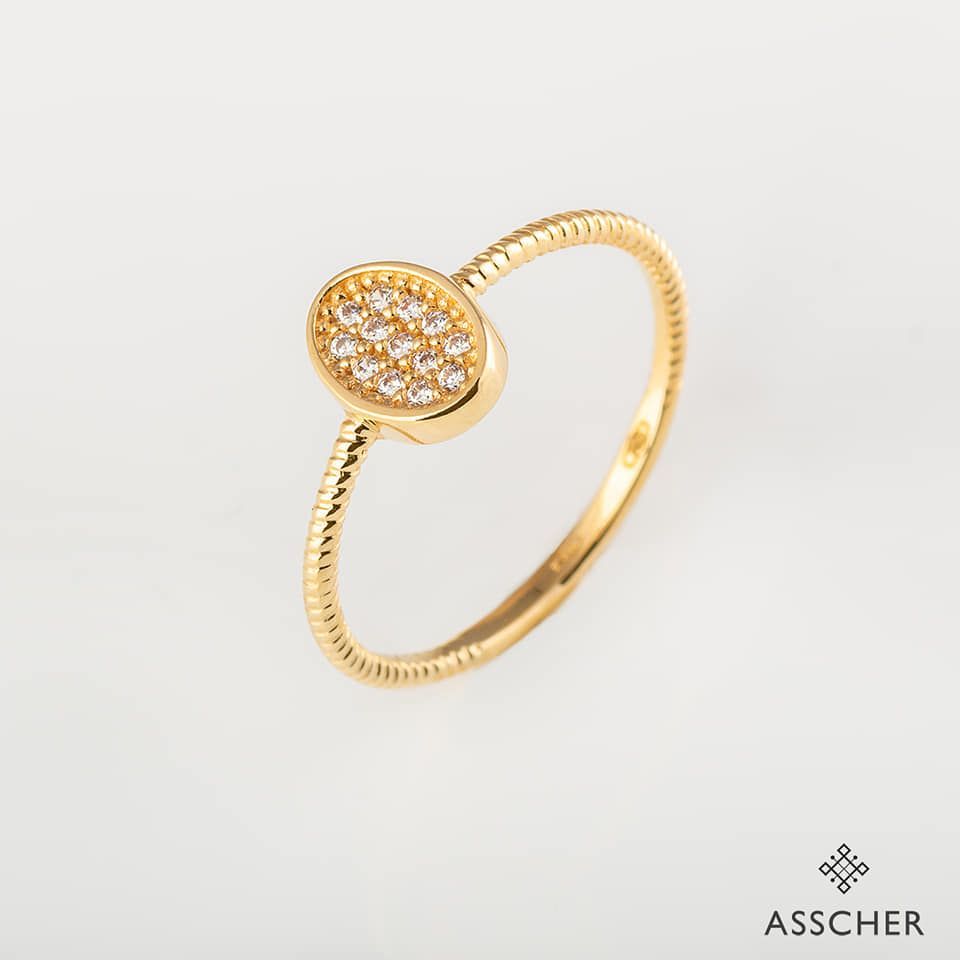 Un anillo de oro con un pequeño óvalo en el centro.