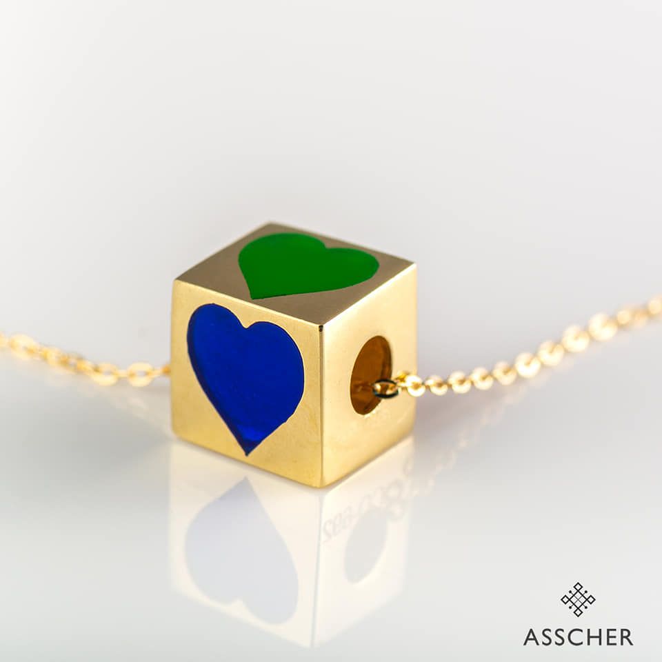 Un cubo dorado con un corazón azul y verde encima.