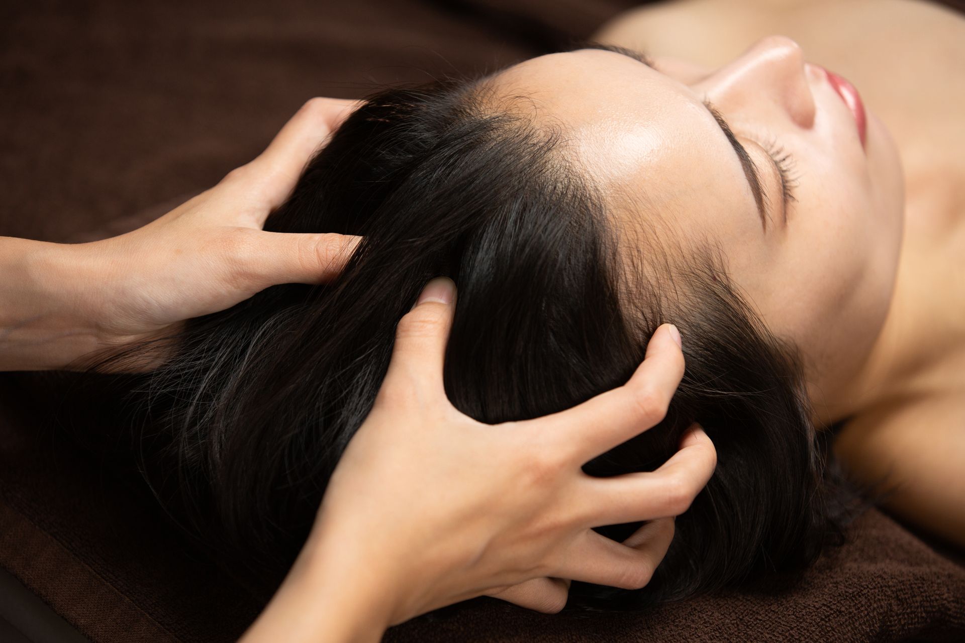 Des pierres lisses empilées, des orchidées et des bougies scintillantes se reflétant sur l'eau.