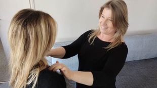 Un praticien touche les épaules d'un client lors d'une séance de massage ou de thérapie énergétique.
