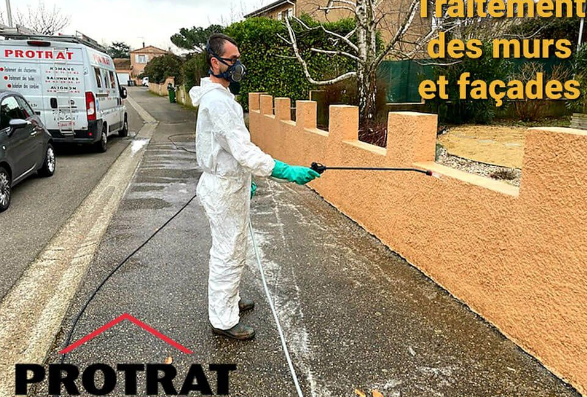 Un homme nettoie un mur.
