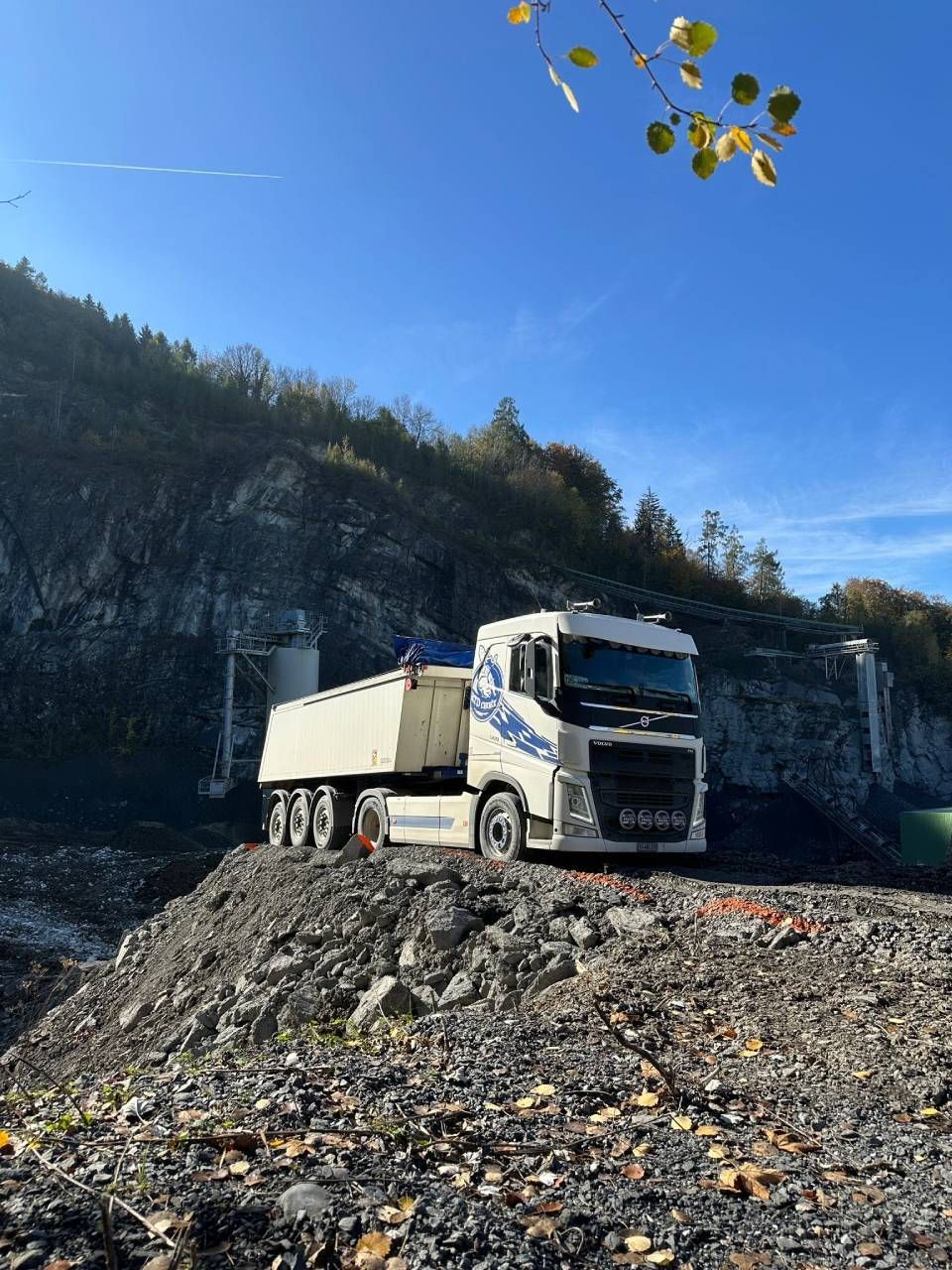 Un camion à benne basculante est garé au sommet d'un tas de rochers.