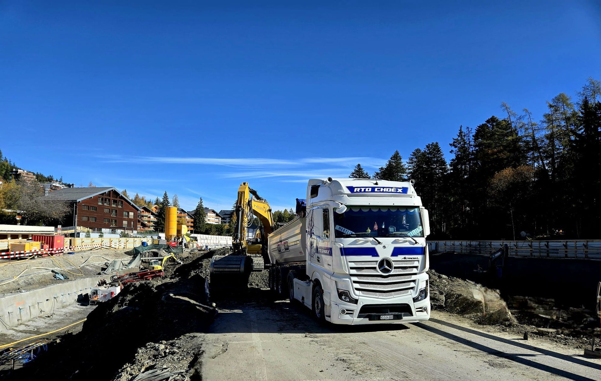 Un camion à benne basculante roule sur une route boueuse