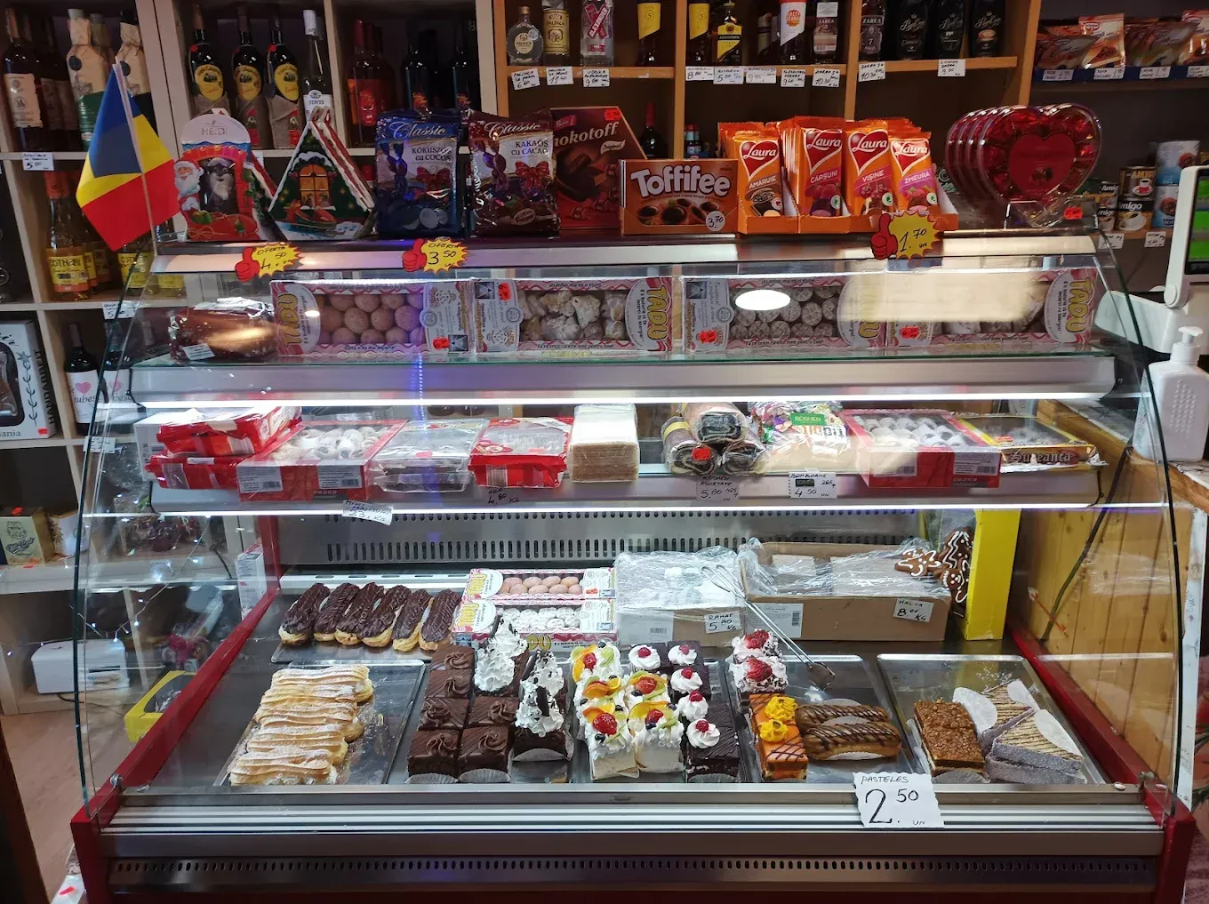 Vitrina llena de diversos pasteles y dulces en una tienda.