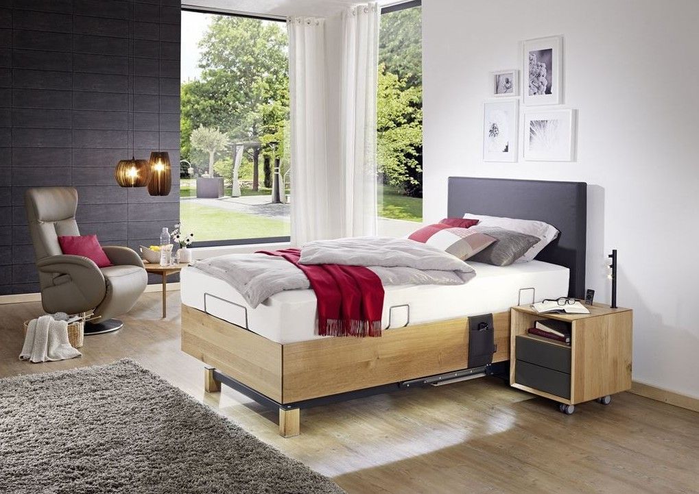 Schlafzimmerinterieur mit Bett, Kissen und dekorativer Beleuchtung an einer blauen Wand.