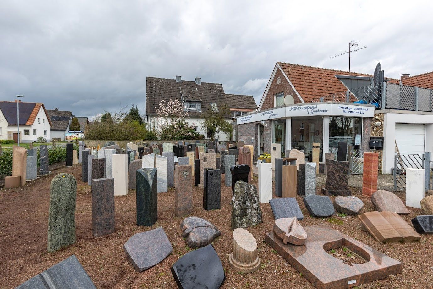 Ein Friedhof mit vielen Gräbern und einem Haus im Hintergrund.