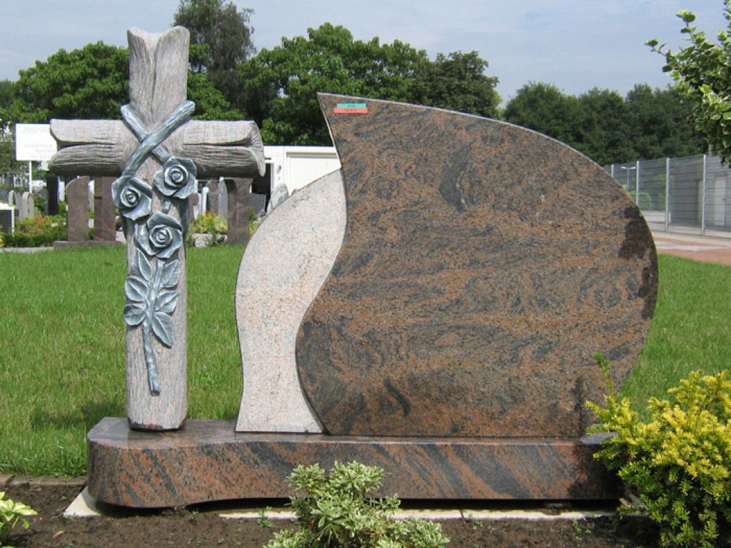 Ein Grabstein mit einem Kreuz und Rosen darauf