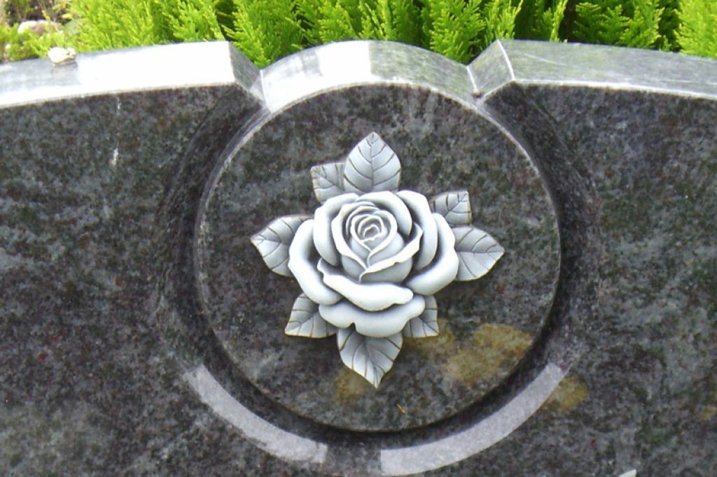 Ein Grabstein mit einer darin geschnitzten Rose