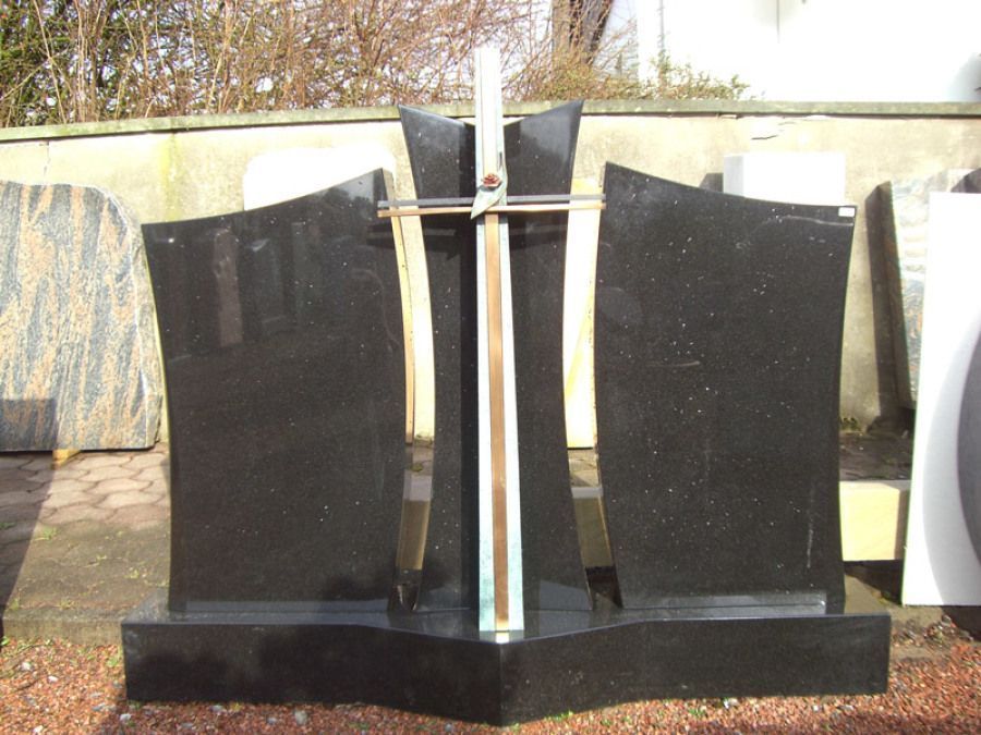 Ein schwarzer Grabstein mit einem Kreuz darauf