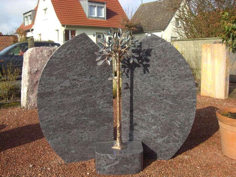 Ein Grabstein mit einem Baum in der Mitte