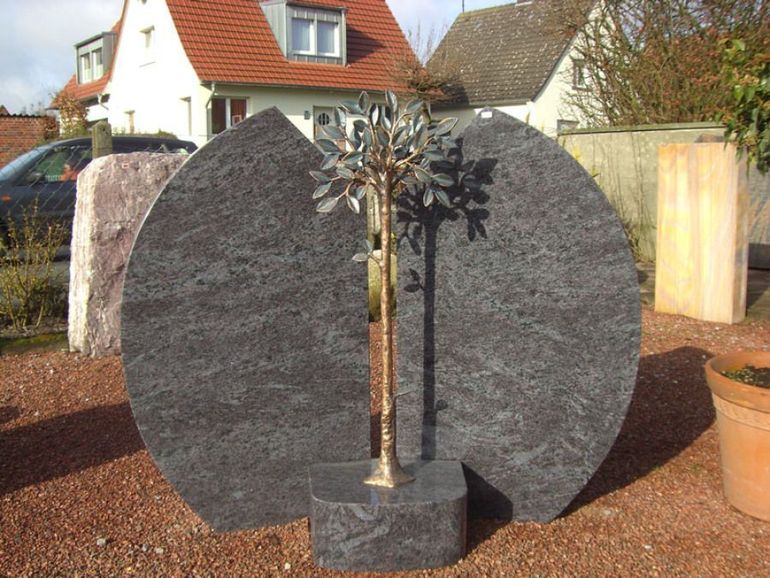 Ein Grabstein mit einem Baum in der Mitte