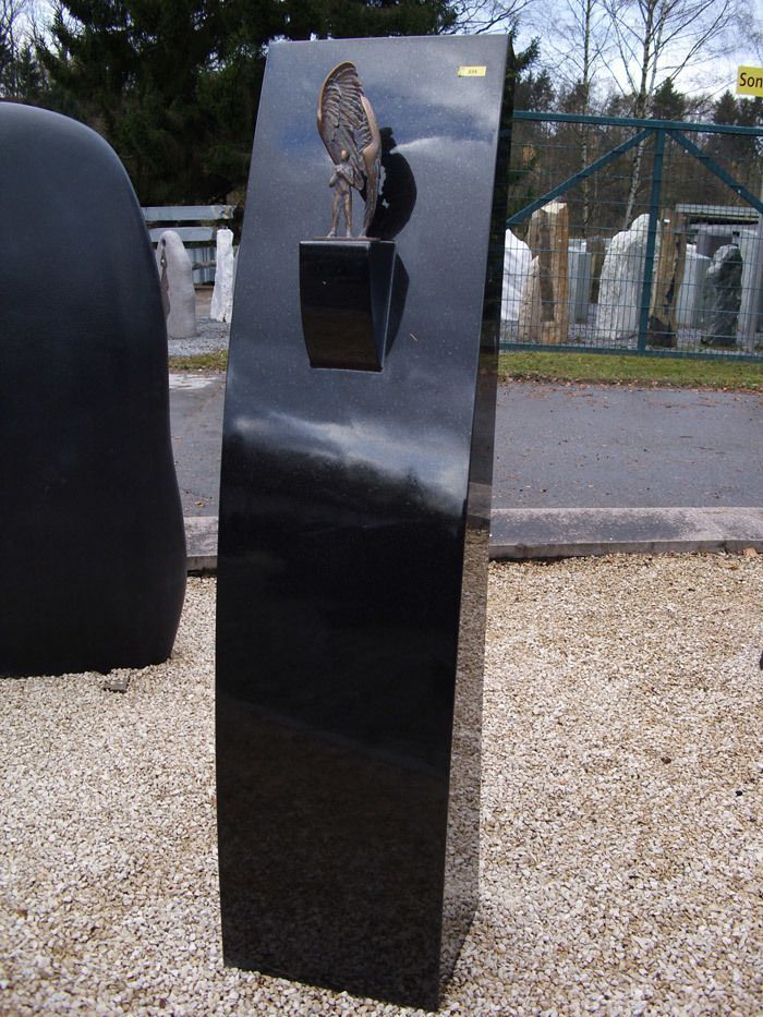 Eine schwarze Skulptur mit einer Statue darauf