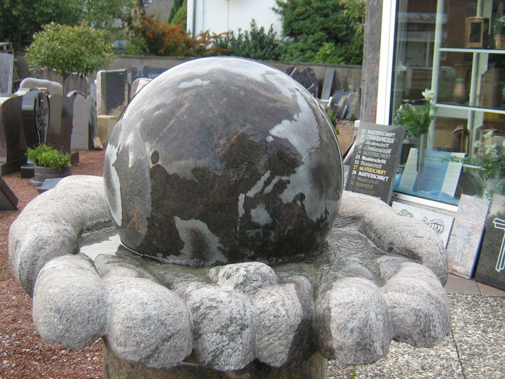 Eine große Steinkugel ist von kleineren Steinen umgeben