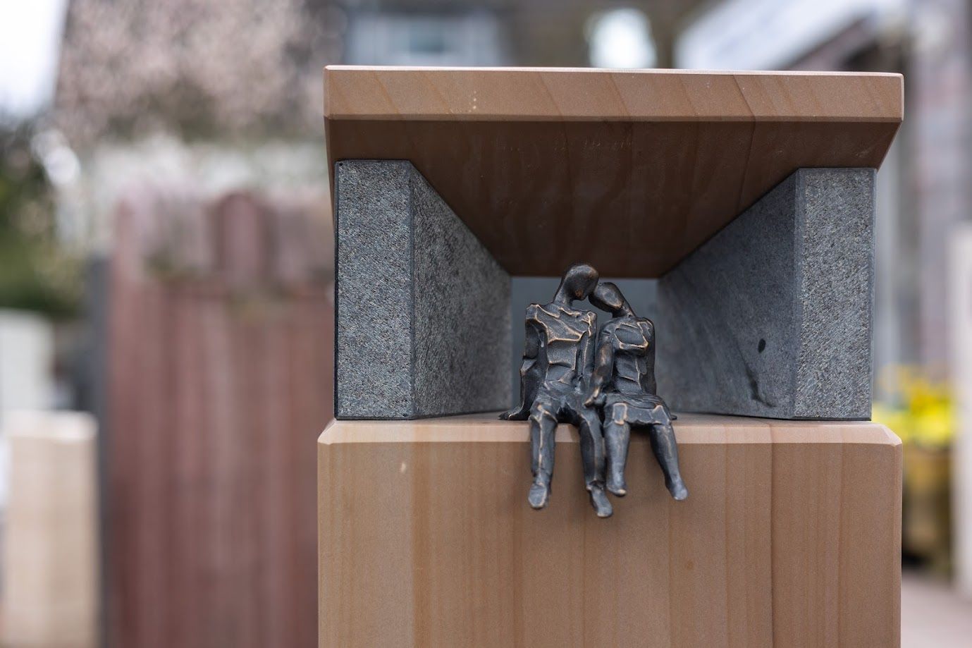 Eine Statue von zwei Personen, die auf einem Holzblock sitzen