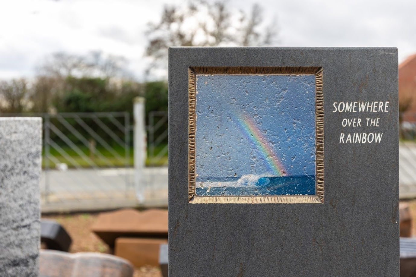 Ein Grabstein mit dem Bild eines Regenbogens und der Aufschrift „irgendwo über dem Regenbogen“.