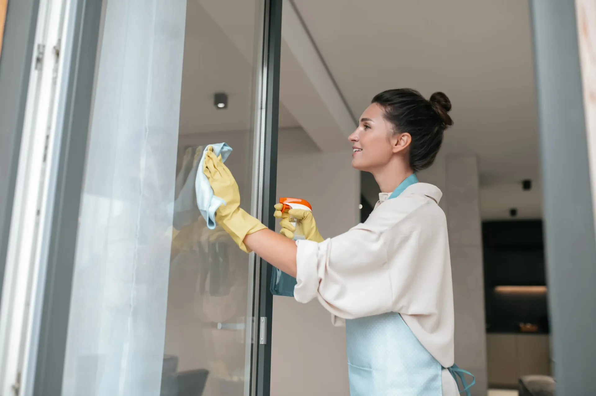 Frau putzt Fenster