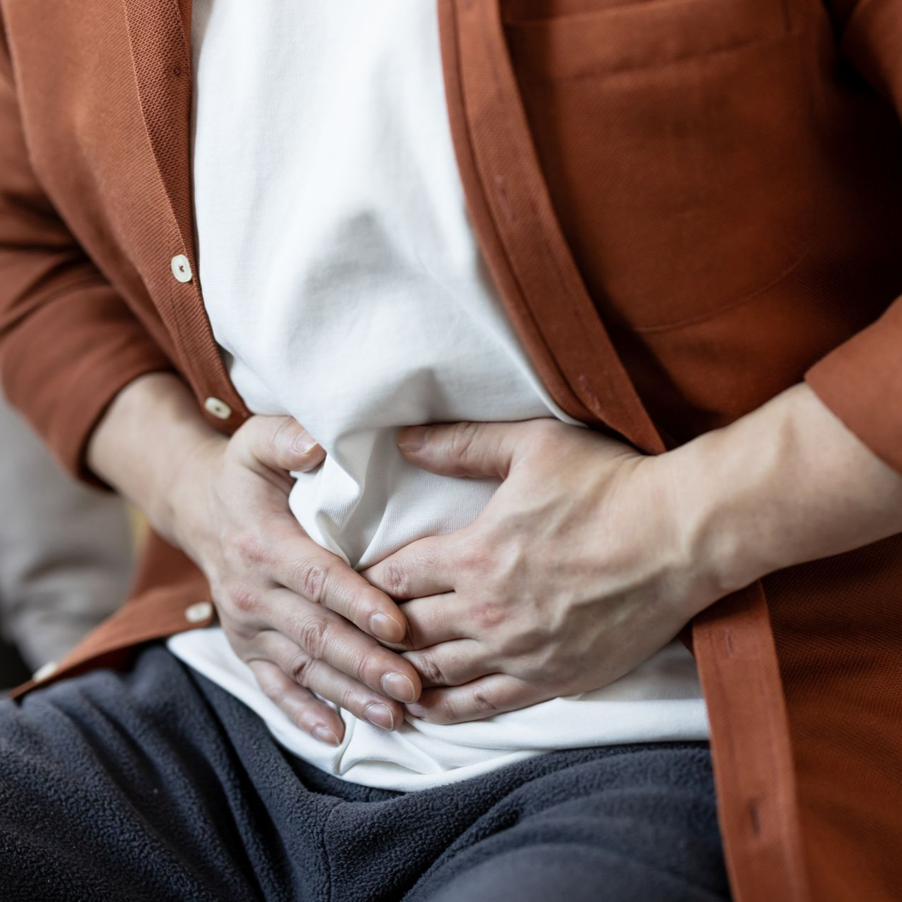 Personne se tenant le ventre, souffrant de douleurs.