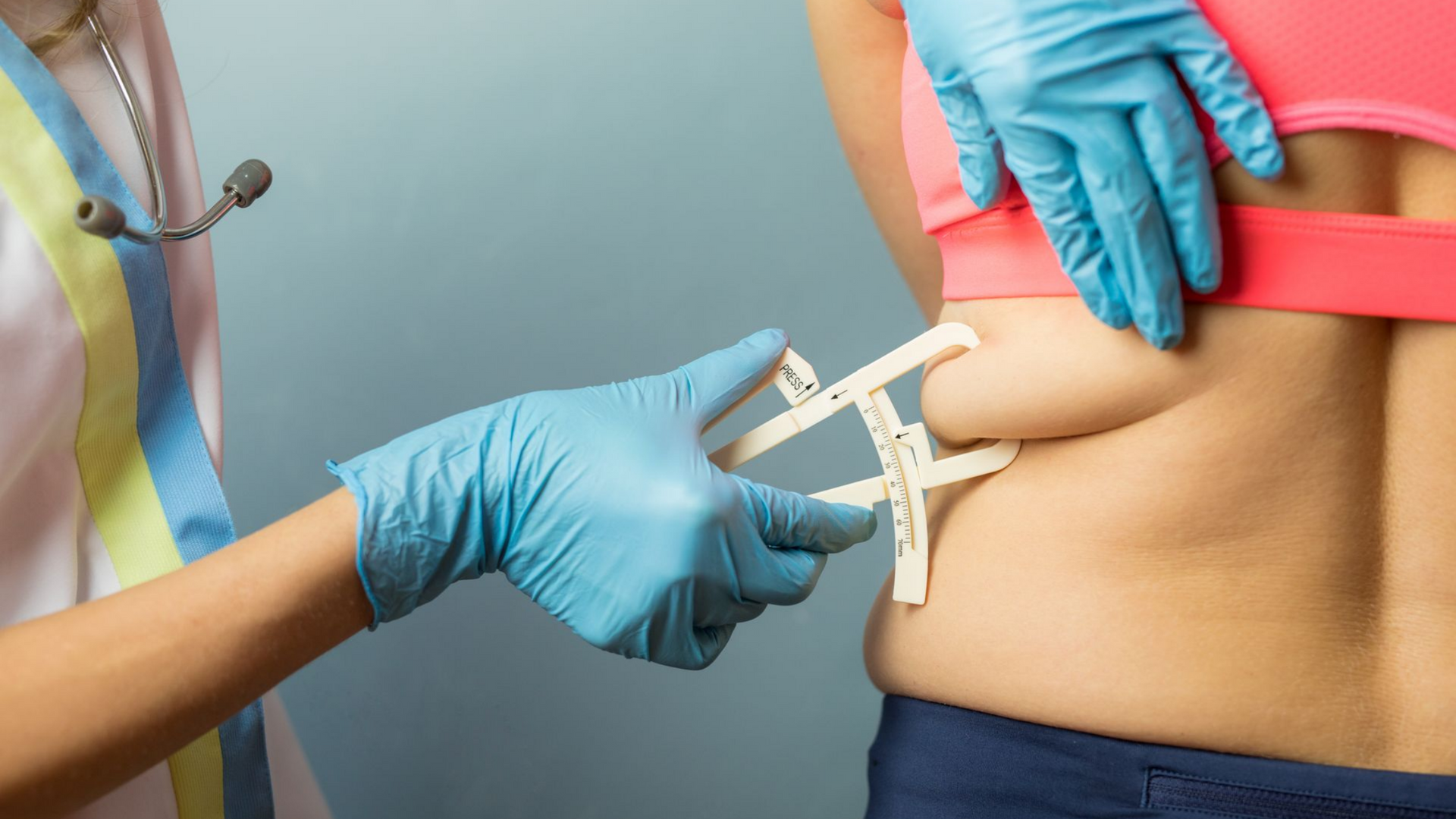 Médecin utilisant un compas pour mesurer un pli cutané dans le dos d'une personne.