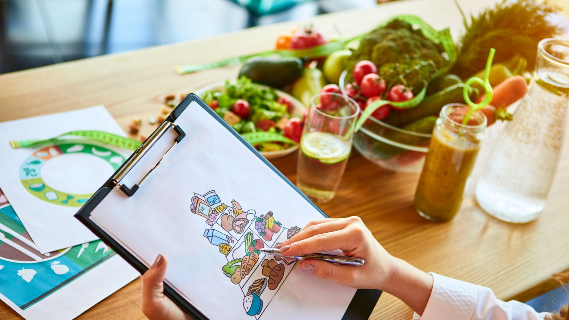 Une personne dessine un schéma alimentaire sur un bloc-notes, entourée de légumes frais.