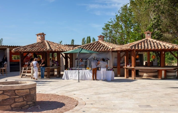 Des stands de nourriture en plein air avec des toits de tuiles sous un ciel ensoleillé.