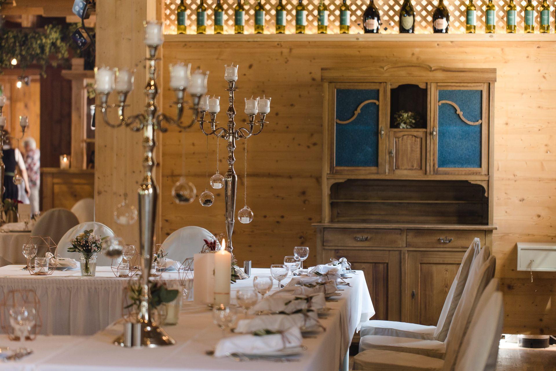 Stadl mit Tischen und Stühlen und Kerzen darauf