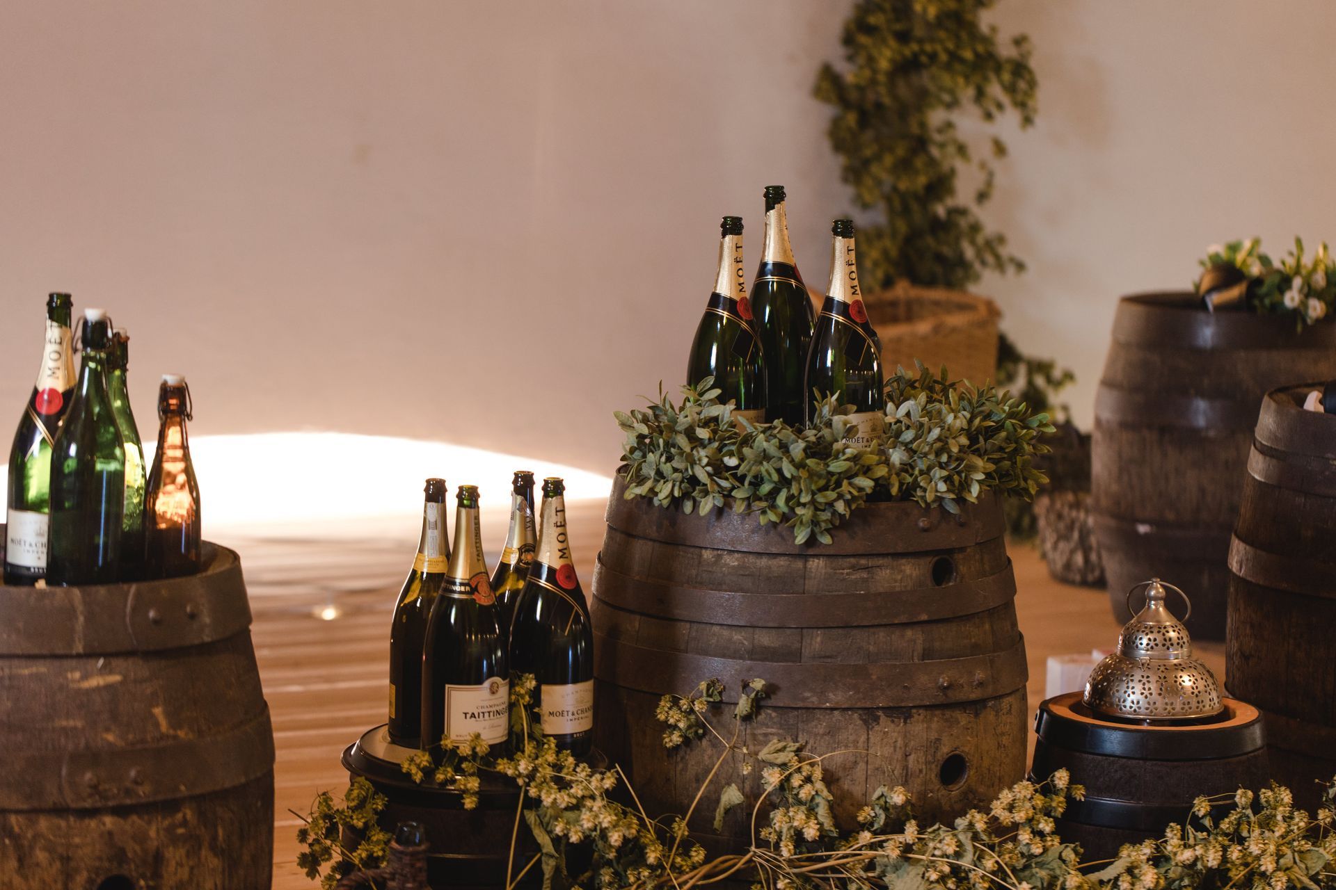 Ein Haufen Weinflaschen steht auf Holzfässern