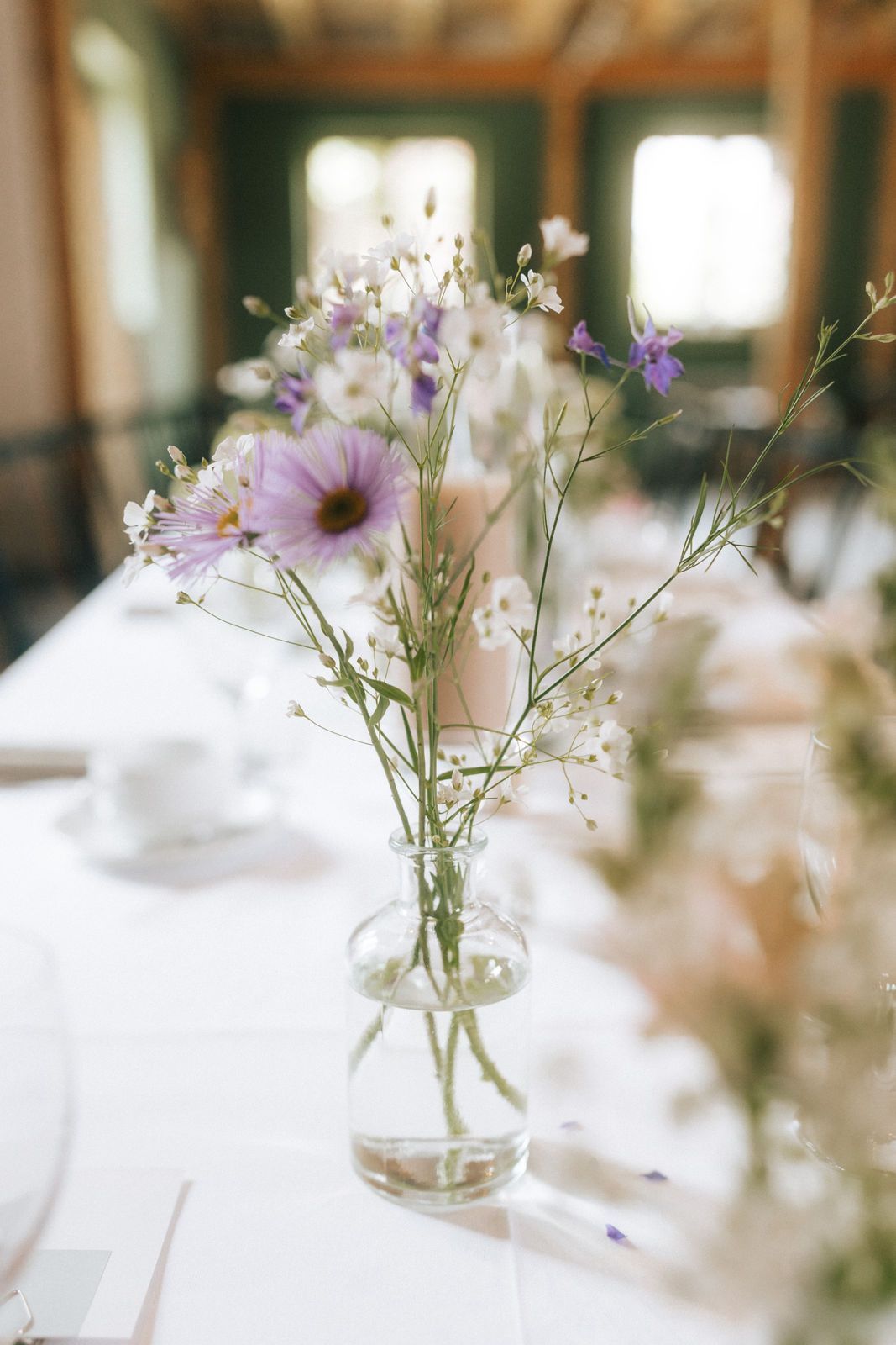 Auf einem Tisch steht eine mit Blumen gefüllte Vase