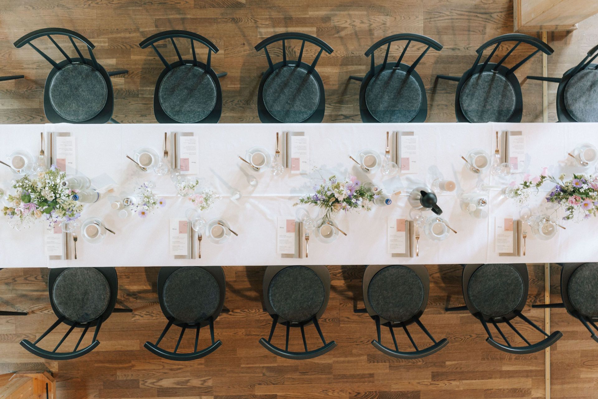 Ein langer Tisch mit Stühlen und Tellern darauf