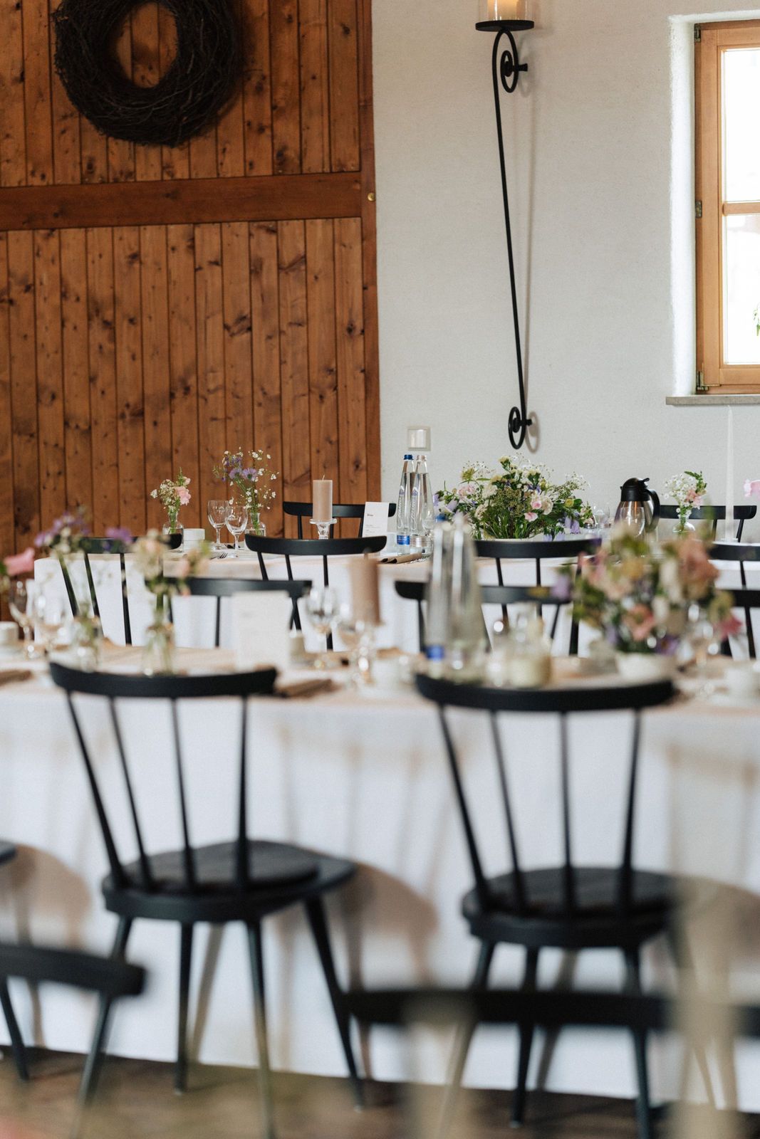 Stadl mit Tischen und Stühlen, aufgestellt für einen Hochzeitsempfang