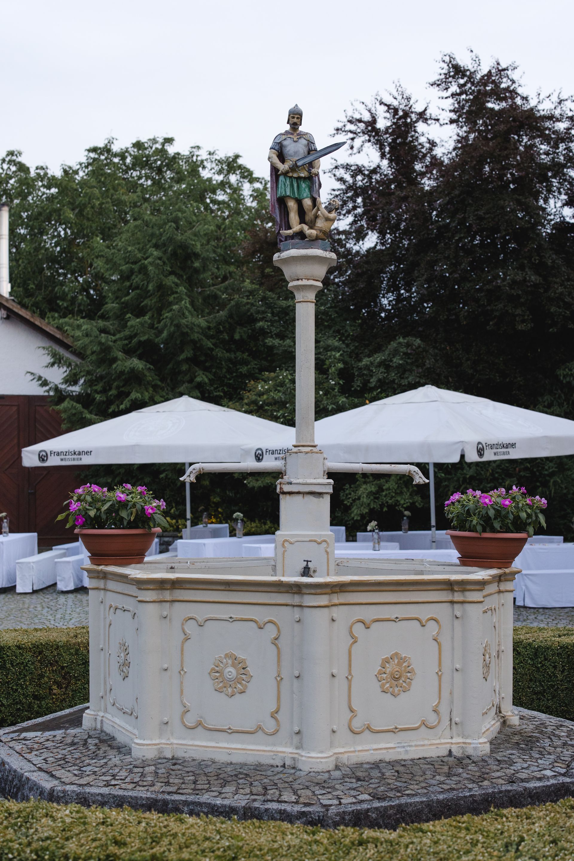 Ein weißer Brunnen mit einer Statue darauf