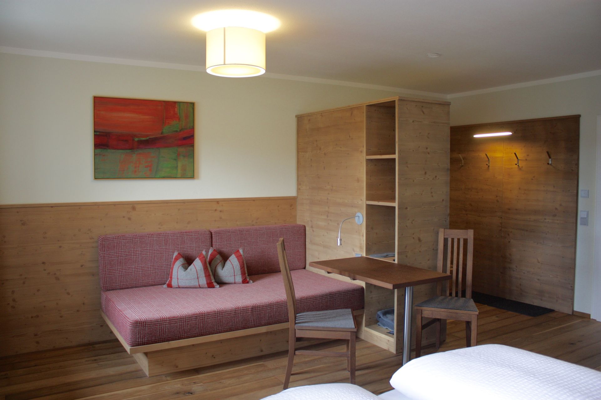 Hotelzimmer mit Sofa, Tisch, Stühlen und einem Gemälde an der Wand