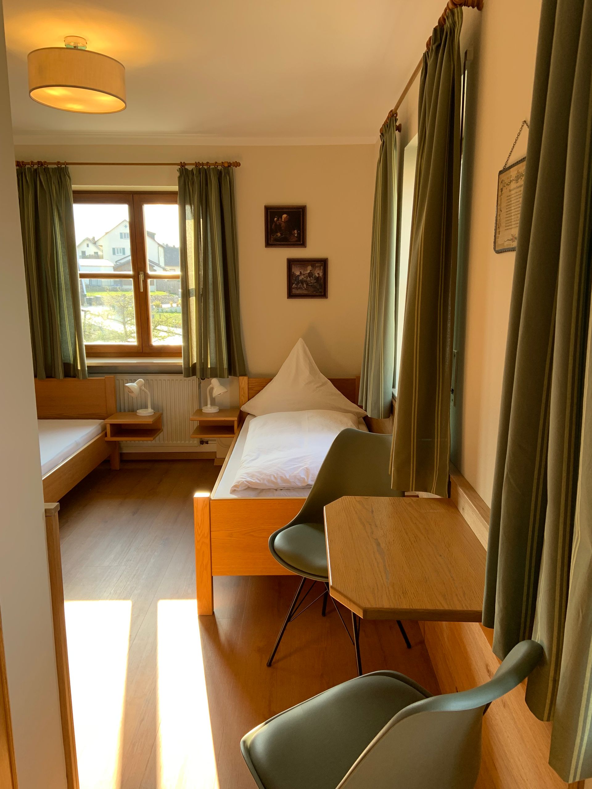 Hotelzimmer mit zwei Betten, einem Tisch und einem Stuhl