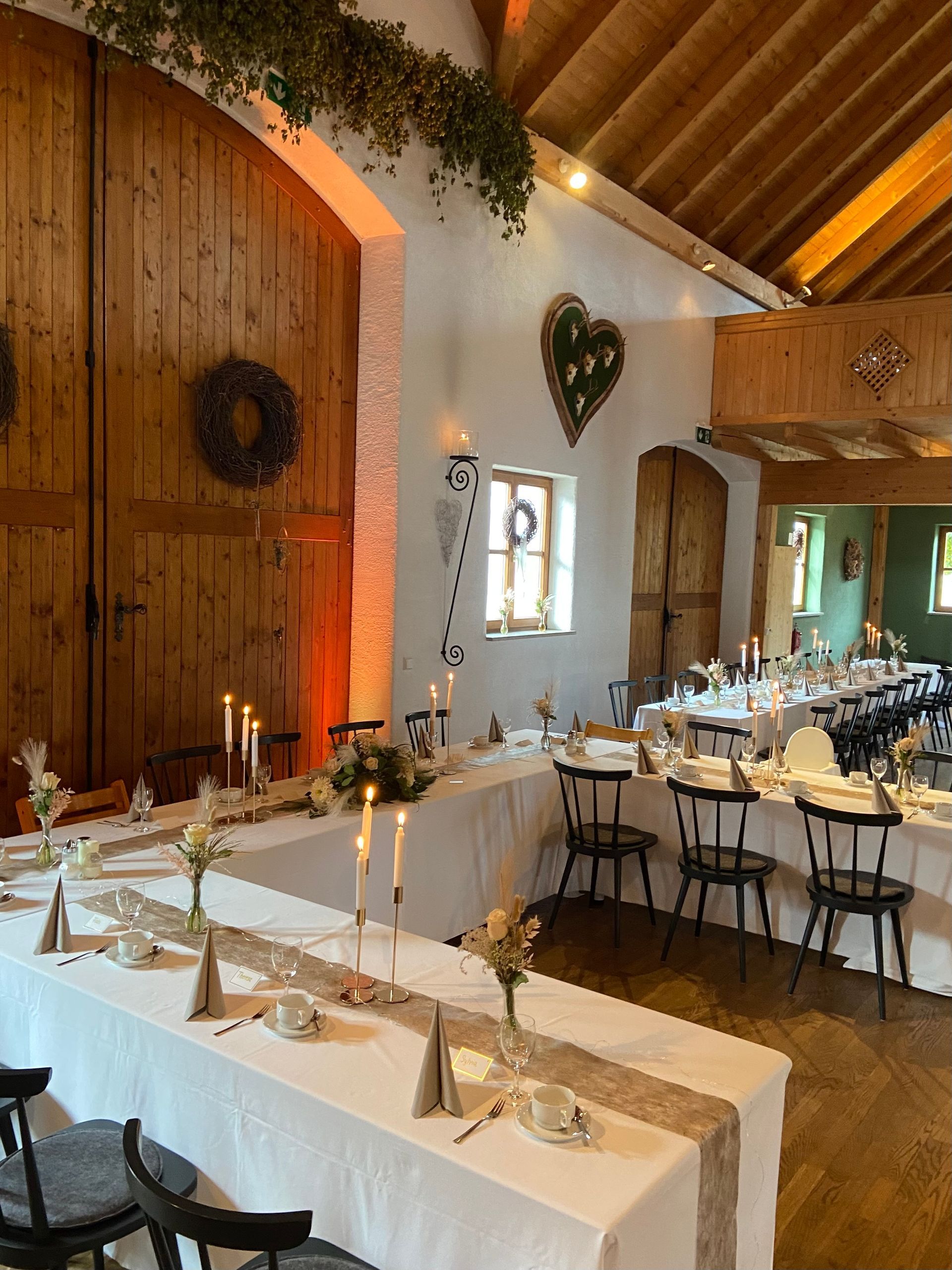 Stadl mit Tischen und Stühlen, aufgestellt für einen Hochzeitsempfang