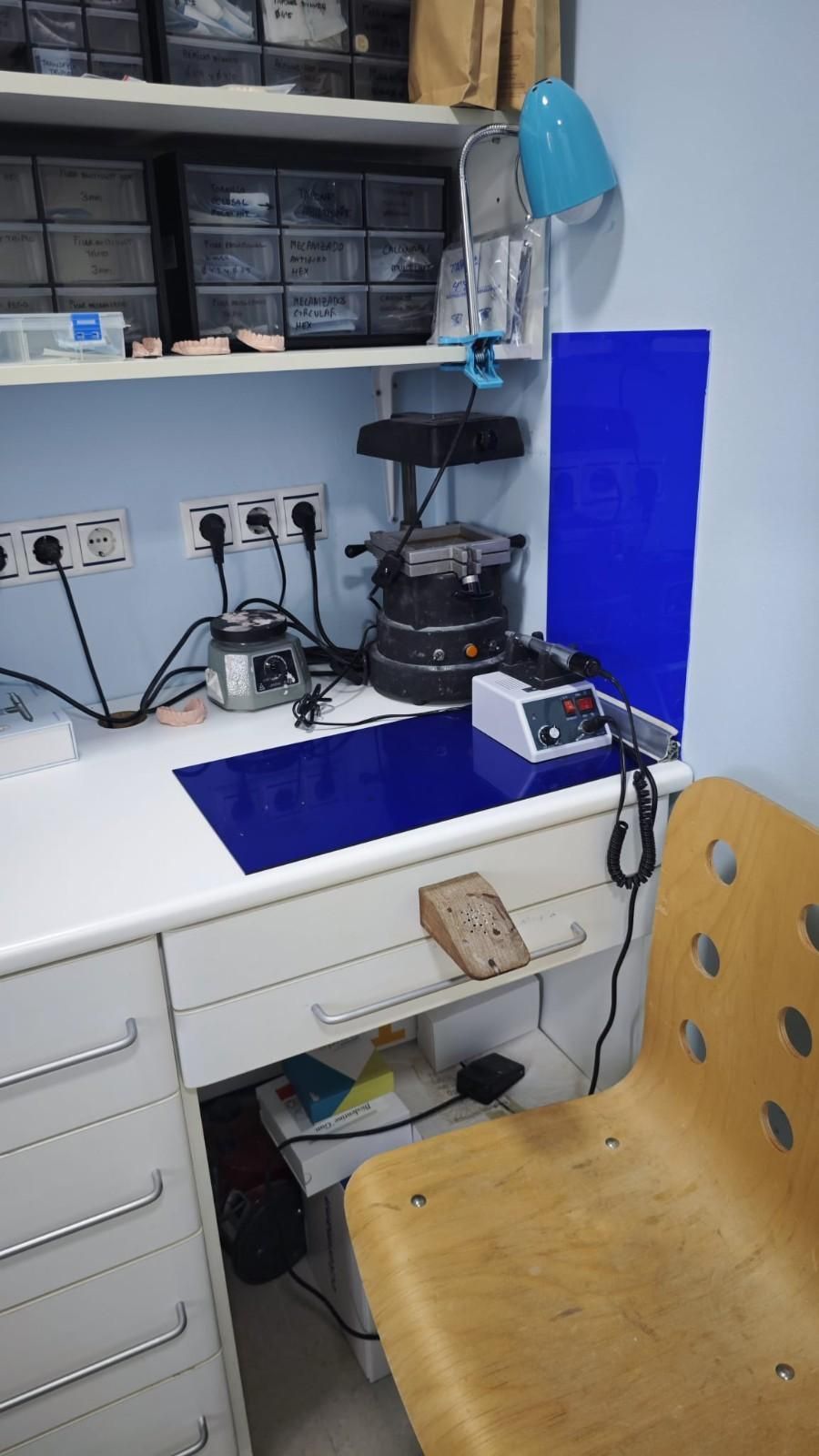 Un pequeño escritorio con una alfombrilla azul, una arrocera eléctrica