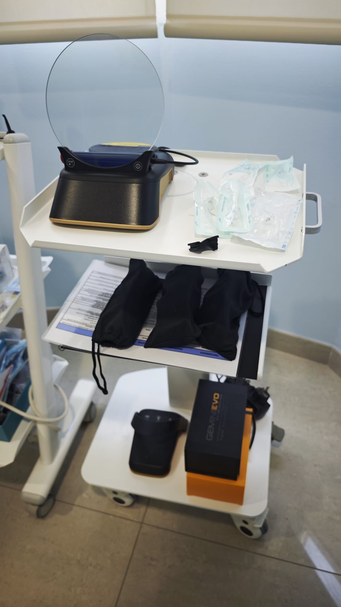 Un carrito utilitario blanco con una máquina de coser, tela doblada