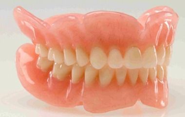 Conjunto de dentadura postiza rosa sobre fondo blanco
