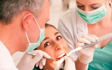 Un dentista examina los dientes de un paciente con instrumental dental 