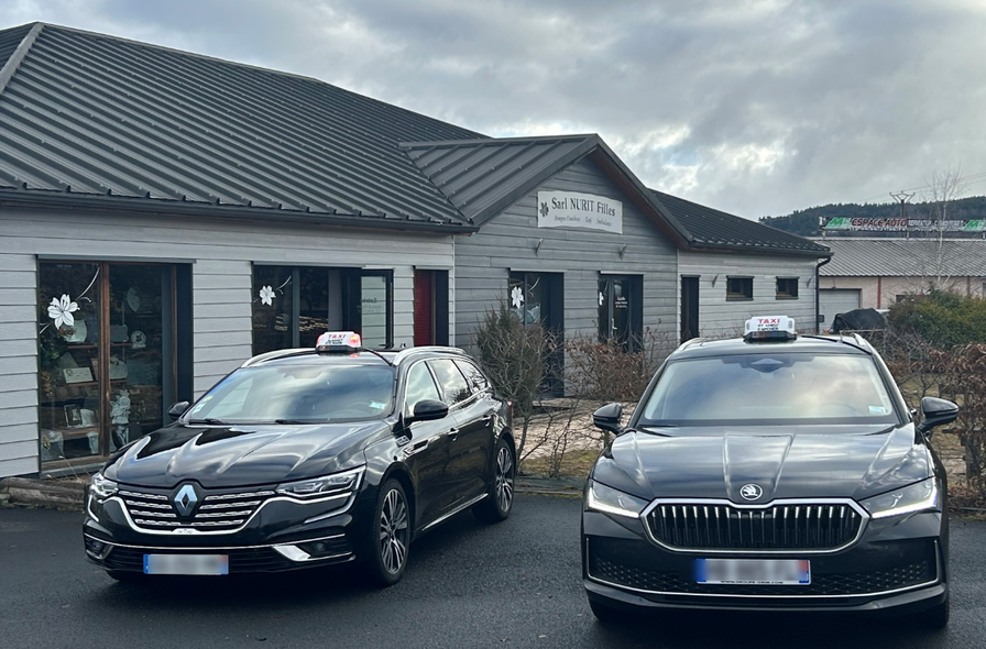 Deux voitures noires garées devant une maison par temps nuageux