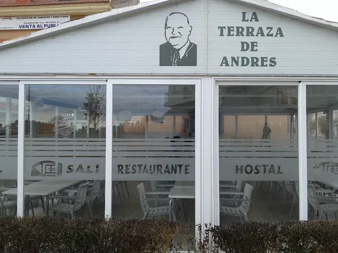 Fachada del restaurante y hostal La Terraza de Andrés con ventanas de cristal y letrero en blanco y negro.