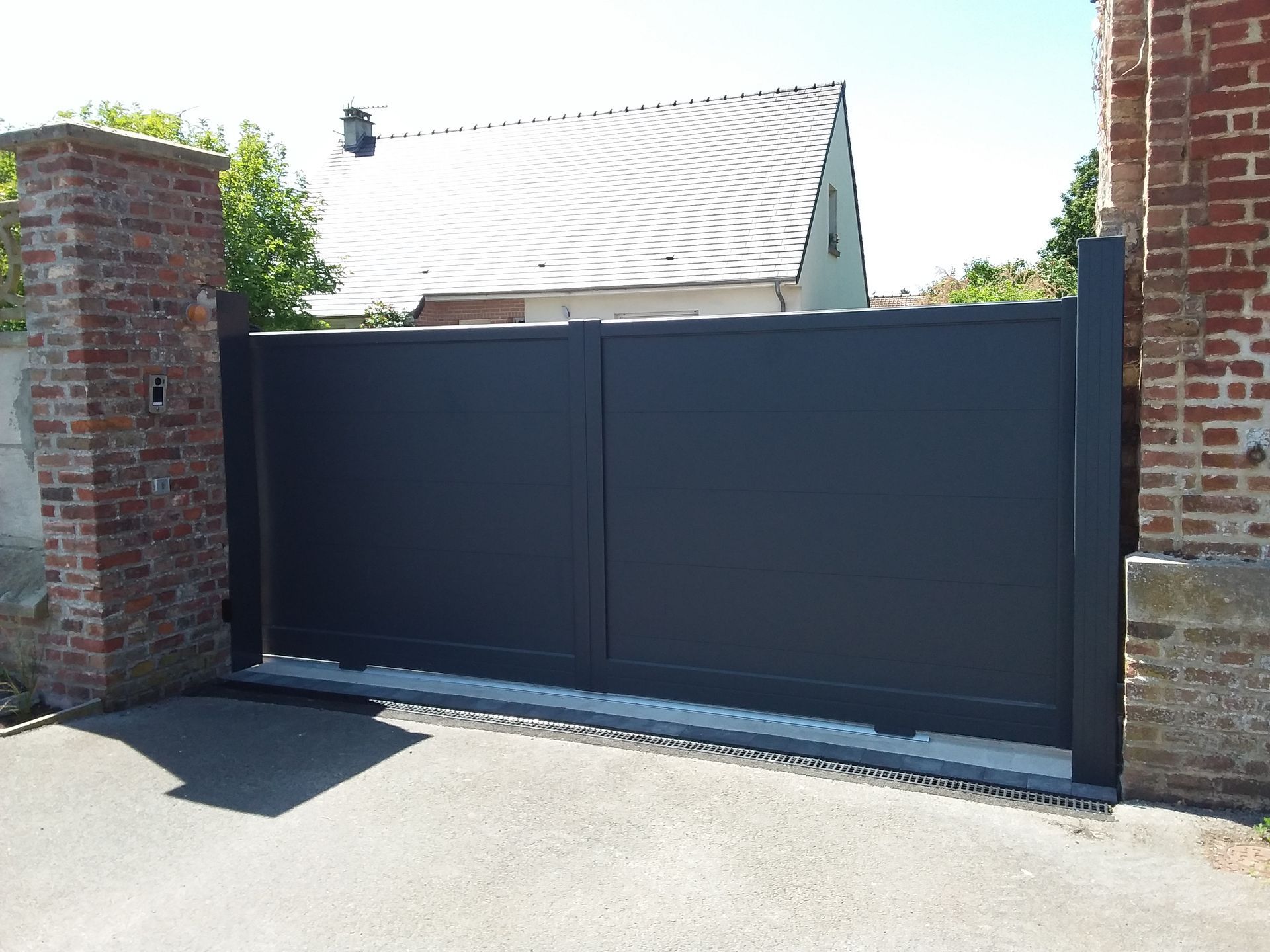 Un portail noir en aluminium.