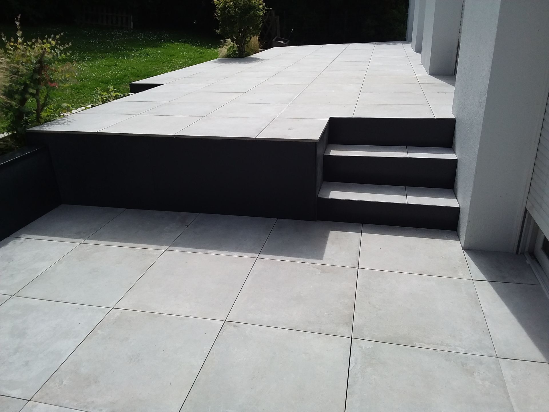 Un petit escalier pour descendre d'une terrasse en carrelage.