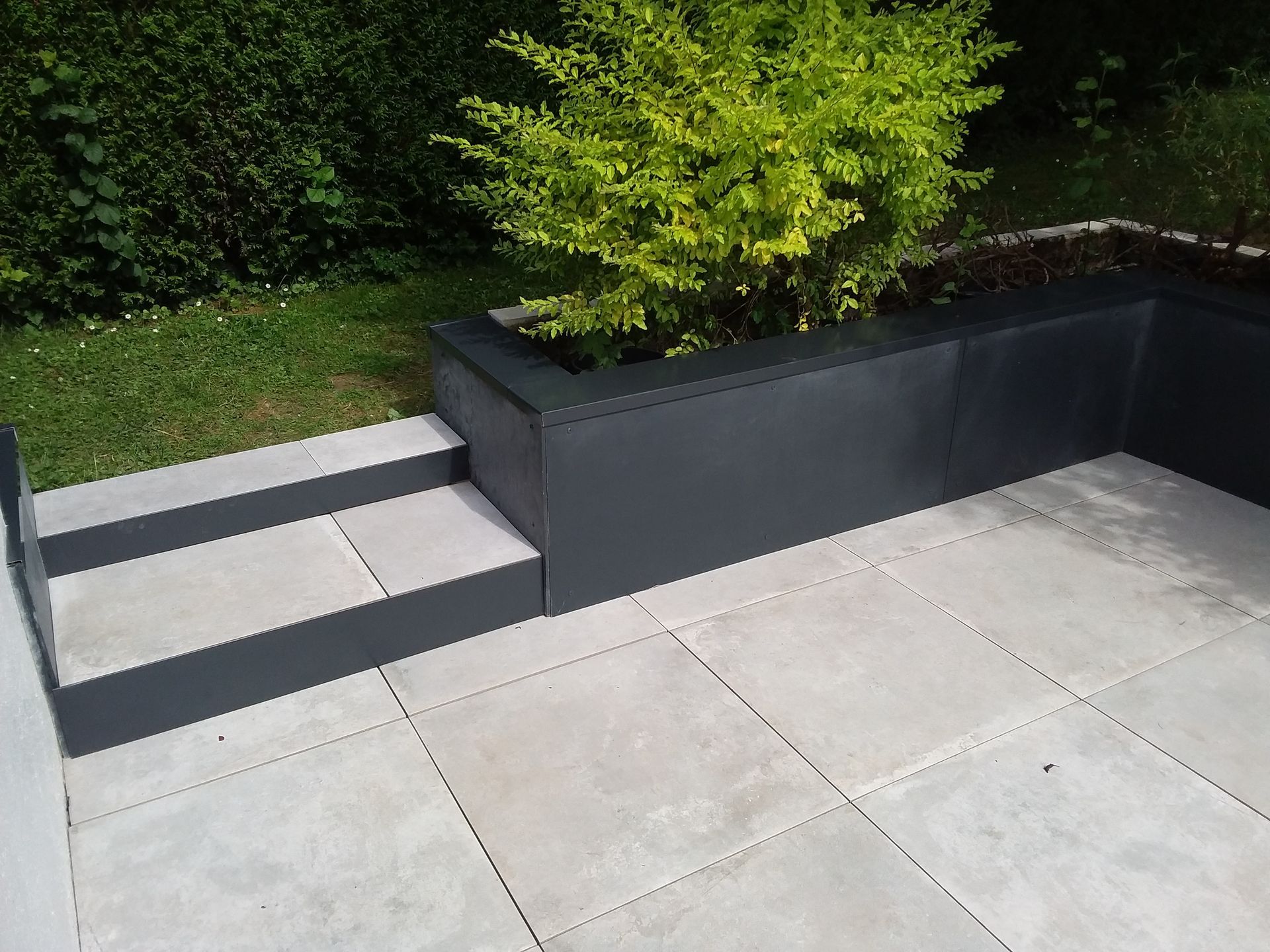 Une terrasse en carrelage avec un petit escalier.