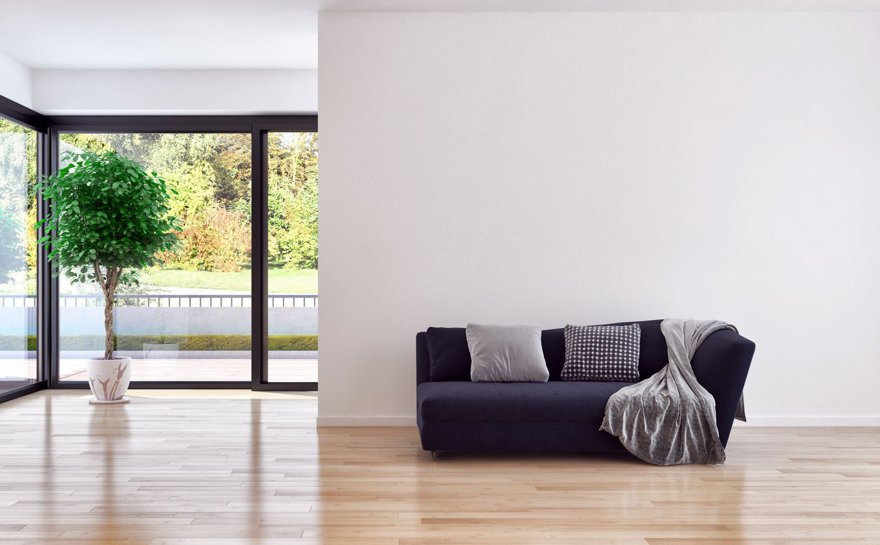 Salon minimaliste avec un canapé, des coussins à motifs, un arbre en pot et des baies vitrées du sol au plafond.