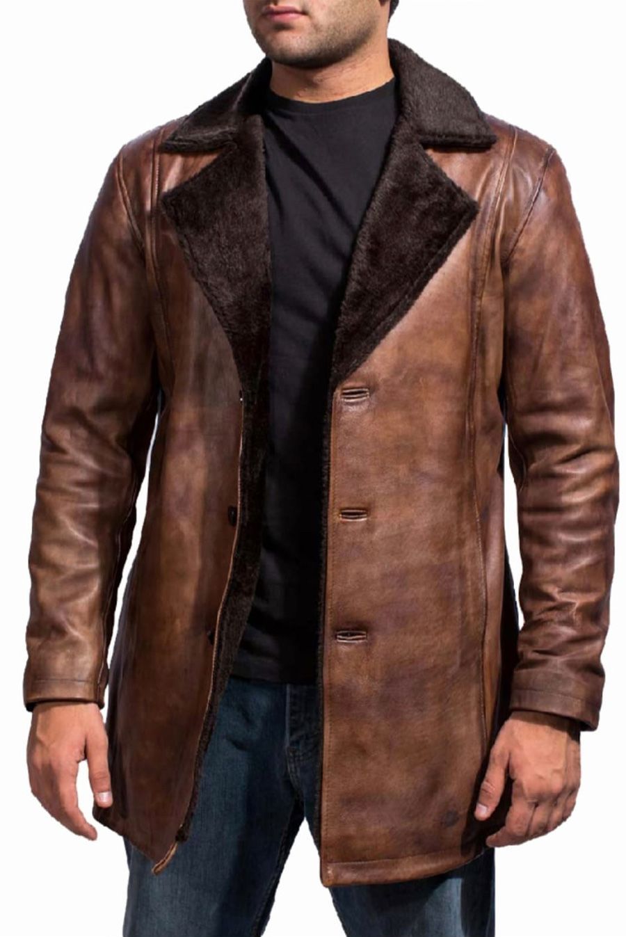 Hombre que lleva un abrigo de cuero marrón con cuello de piel oscura sobre una camisa negra y jeans azules.