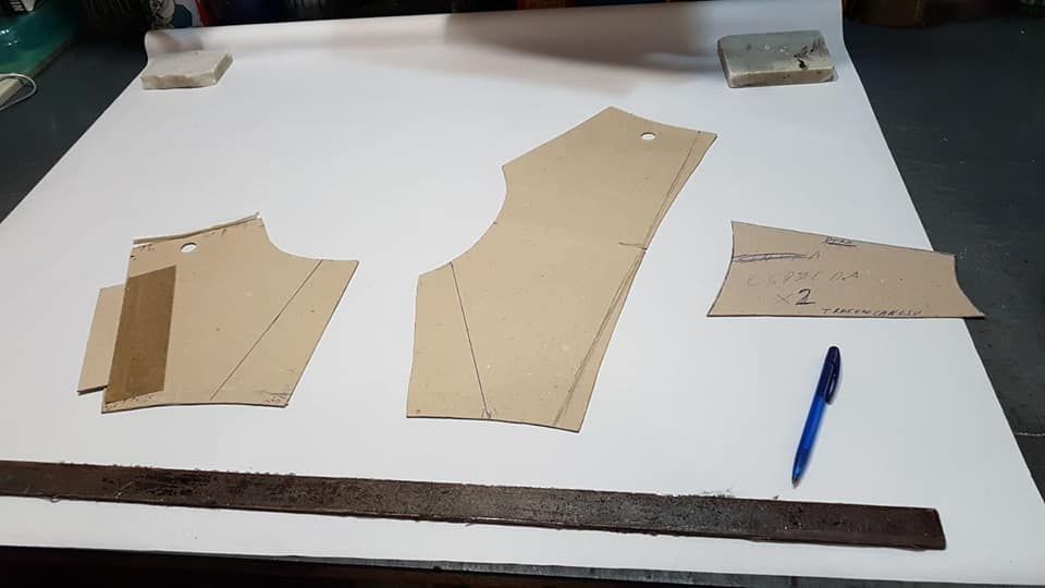 Piezas del patrón del vestido, bolígrafo y regla sobre papel blanco.