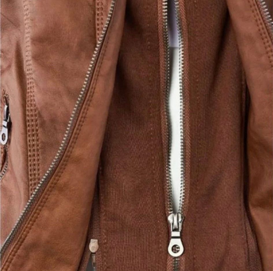 Chaqueta de cuero marrón con cremalleras parcialmente abiertas.