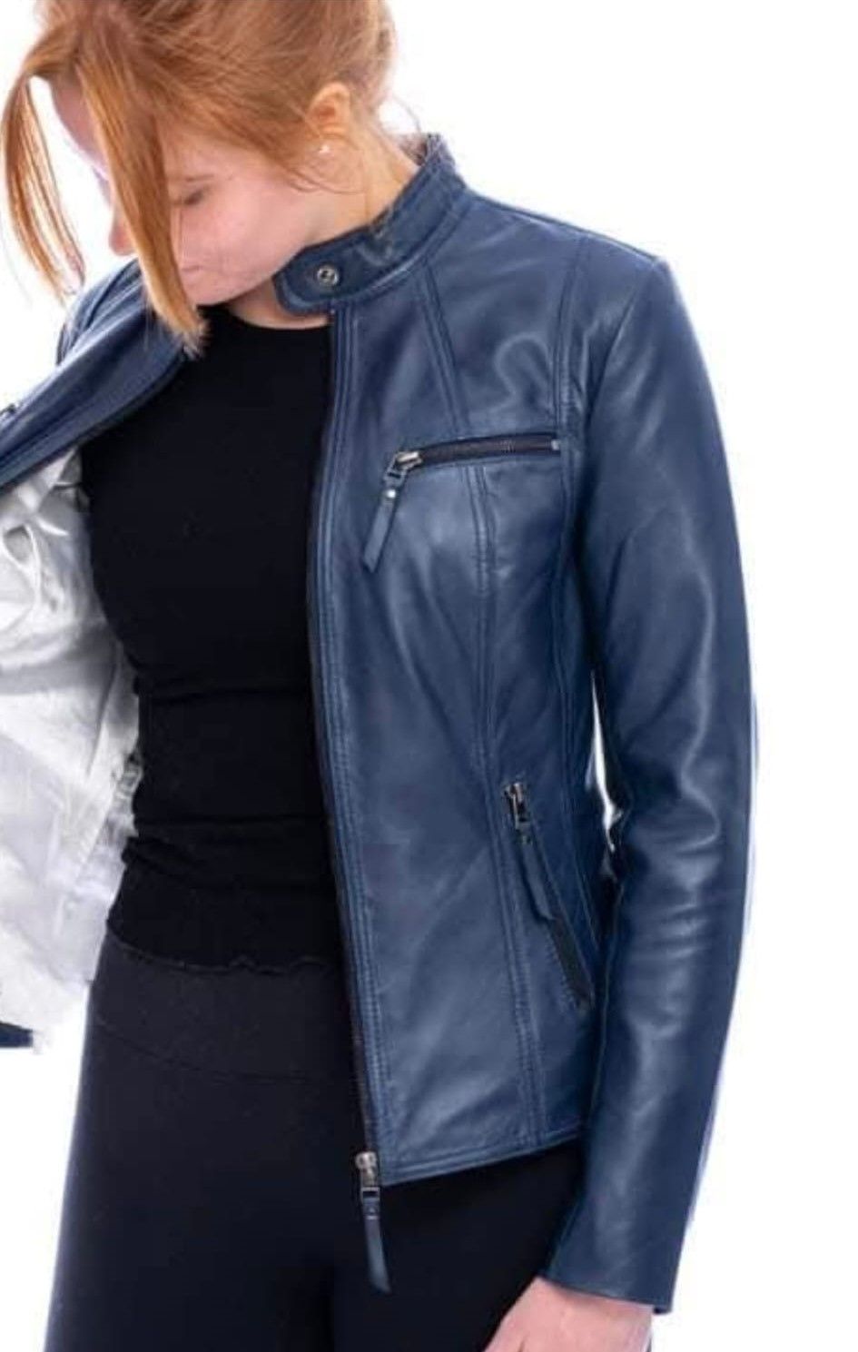 Mujer con chaqueta de cuero azul marino, desabrochada sobre una camisa negra, sobre fondo blanco.