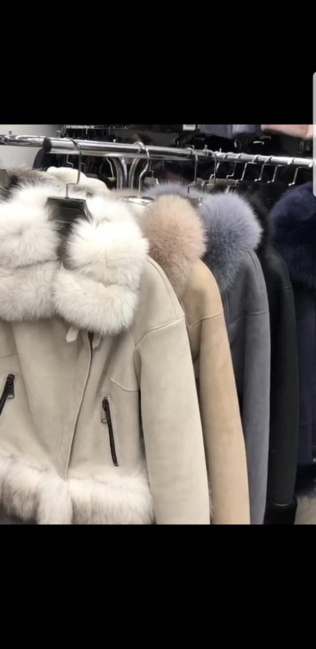 Abrigos de piel colgados en un perchero en una tienda. Se aprecian varios colores, entre ellos el blanco y el gris.